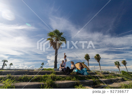 夏の海の海岸でマーメイド撮影している女性と子供の姿 92736677