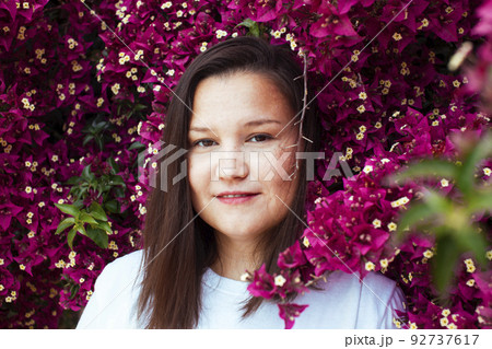 young pretty brunette girl surrounded by purple flowers, lifstyle people touristic season close up 92737617