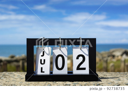 Jul 02 calendar date text on wooden frame with blurred background of ocean. Jul 02 calendar date text on wooden frame with blurred background of ocean. 92738735