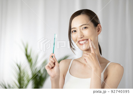 緑の歯ブラシを持つ女性 92740395