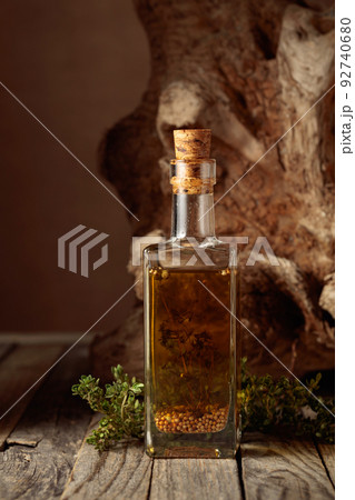 Olive oil with thyme and spices on an old wooden table. 92740680