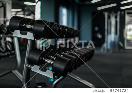 Sports equipment concept. Set of dumbbells placed on the rack in gym 92741724