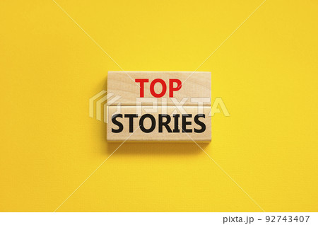 Top stories symbol. Concept words Top stories on wooden blocks on a beautiful yellow table yellow background. Business story and top stories concept, copy space. 92743407