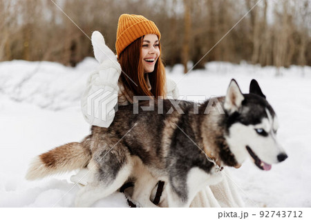 Happy young woman in the snow playing with a dog fun friendship Lifestyle Happy young woman in the snow playing with a dog fun friendship Lifestyle 92743712