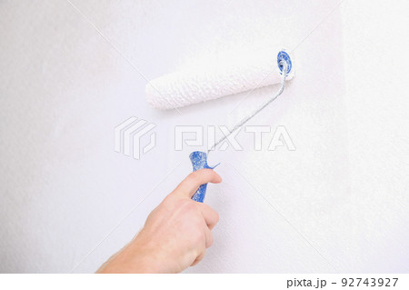 A man is painting vinyl wallpaper with velour 92743927