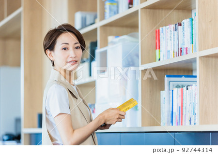 オフィスで書庫の前に立つビジネスウーマン オフィスで書庫の前に立つビジネスウーマン 92744314