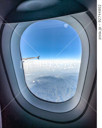 Clouds and sky as seen through window of an aircraft 92744802