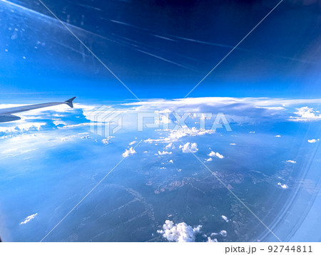 Clouds and sky as seen through window of an aircraft 92744811