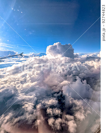 Clouds and sky as seen through window of an aircraft Clouds and sky as seen through window of an aircraft 92744823