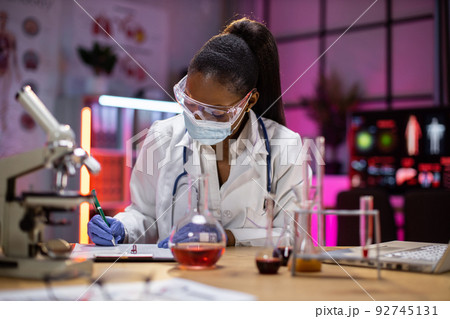 woman microbiologist or medical worker writing research results in the laboratory. woman microbiologist or medical worker writing research results in the laboratory. 92745131