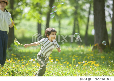シャボン玉を追いかける男の子 92748101