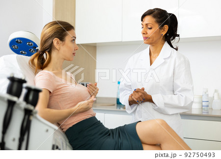 Young woman talking about mammoplasty with cosmetic surgeon 92750493