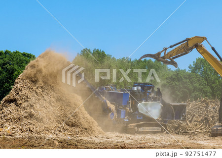 In the shredding machine of a work conveyor, wood chips are produced from wood roots in a stationary industrial shredder In the shredding machine of a work conveyor, wood chips are produced from wood roots in a stationary industrial shredder 92751477