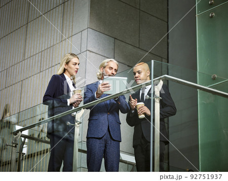 multinational and multiethnic corporate people discussing business using digital tablet in modern office building 92751937