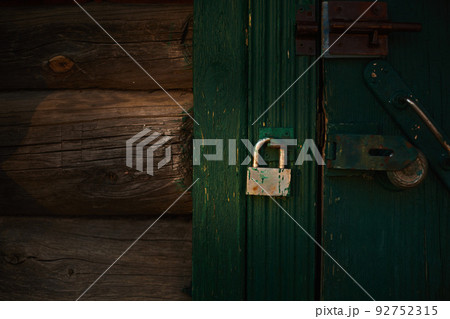 Rusty lock on the old wooden door. Front view. 92752315