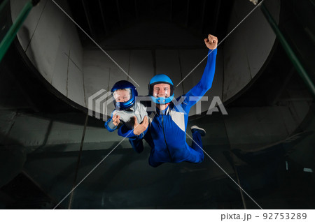 A man teaches a boy to fly in a wind tunnel. Lack of gravity. 92753289