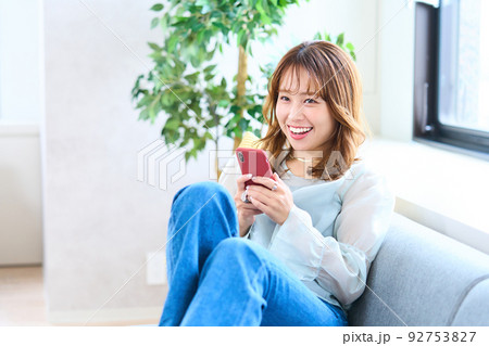 私服の若い女性　リビング　スマホ 92753827