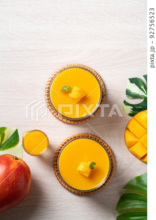 Delicious mango panna cotta mousse pudding on white table background. Delicious mango panna cotta mousse pudding on white table background. 92756523
