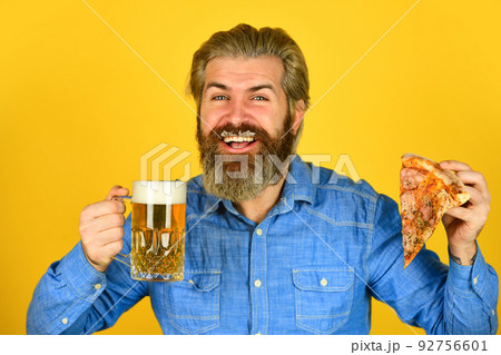 Beer and food. Dinner at pub. Hungry man going to eat pizza and drink beer. 92756601