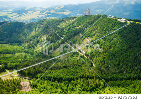 Sky Bridge 721 is the longest suspension bridge between two hills in the forest, Dolni Morava, Czech Republic . One way footbridge in touristic place in the forest in summer. Sky Bridge 721 is the longest suspension bridge between two hills in the forest, Dolni Morava, Czech Republic . One way footbridge in touristic place in the forest in summer. 92757563
