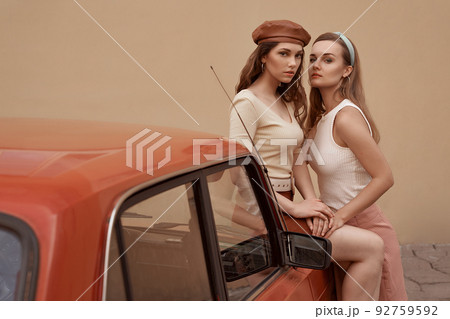 Young beautiful models dressed in retro vintage style enjoying the old european city summertime lifestyle. Old fashioned clothes. Young beautiful models dressed in retro vintage style enjoying the old european city summertime lifestyle. Old fashioned clothes. 92759592