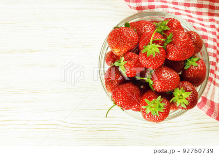 Strawberry in a bowl on white wooden background Strawberry in a bowl on white wooden background 92760739
