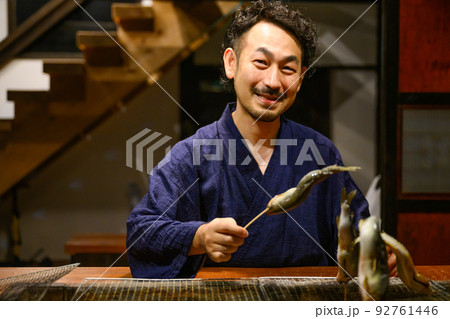 囲炉裏で魚を焼く人 92761446