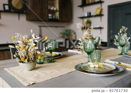 A beautiful festive dining table in the rustic style. Dried flowers in a ceramic vase on the table 92761730