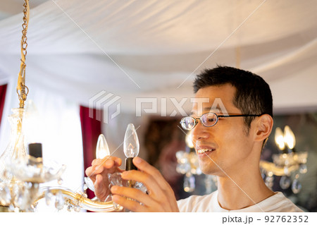 シャンデリアの電球を交換する男性 シャンデリアの電球を交換する男性 92762352