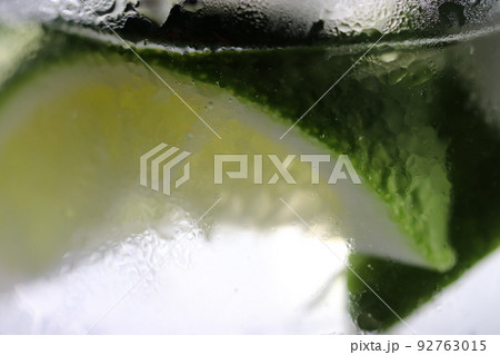 よく冷えたお酒とライムが入ったグラスを接写。グラス表面の霜が清涼感を感じさせる。 92763015