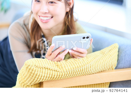 私服の若い女性　リビング　スマホ 92764141