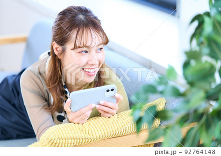 私服の若い女性 リビング スマホ 私服の若い女性 リビング スマホ 92764148