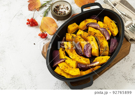 Healthy baked food. Keto, paleo diet, veggie or vegetarian meal. Roasted pumpkins slice with rosemary and purple onion on a stone tabletop. Copy space. Healthy baked food. Keto, paleo diet, veggie or vegetarian meal. Roasted pumpkins slice with rosemary and purple onion on a stone tabletop. Copy space. 92765899