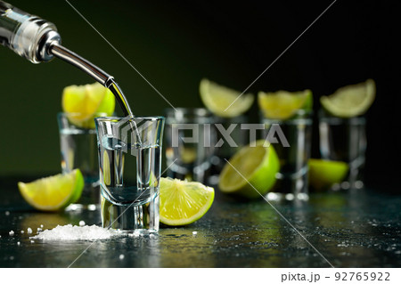 Tequila shots with lime slices and sea salt. Tequila shots with lime slices and sea salt. 92765922