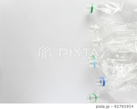 白い画用紙の右端に置いた複数の潰れたペットボトル容器とコピースペース 白い画用紙の右端に置いた複数の潰れたペットボトル容器とコピースペース 92765954
