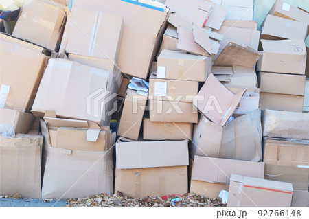 Cardboard and waste paper is collected and packaged for recycling in city. Pile of cardboard is sorting for recycled. 92766148