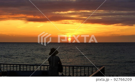佇む女性と海の夕焼。 92766209