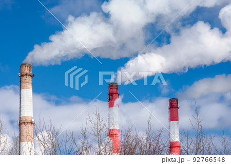 Close-up of the pipes of a thermal power plant with white steam in winter. The concept of environmental pollution and emissions of harmful substances into the atmosphere. Close-up of the pipes of a thermal power plant with white steam in winter. The concept of environmental pollution and emissions of harmful substances into the atmosphere. 92766548