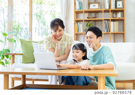 リビングでパソコンを見る若い家族 リビングでパソコンを見る若い家族 92766578