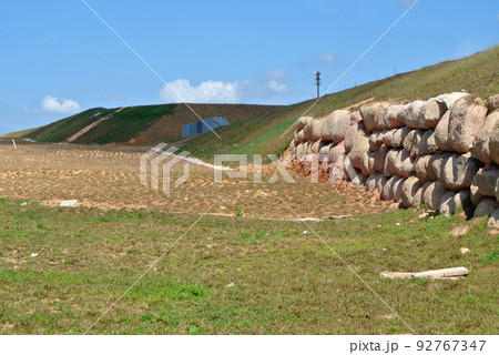 Natural boulders are used as retaining walls of ground banks that have been embanked. Other exposed slopes are planted with grass to prevent erosion caused by rain. 92767347