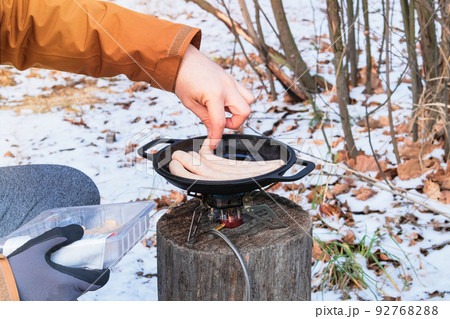 Camping food making. Tourist foods in outdoor activities. Sausages in bowler in the forest in winter. Camping food making. Tourist foods in outdoor activities. Sausages in bowler in the forest in winter. 92768288