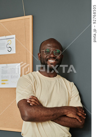 Portrait of African successful businessman in eyeglasses standing with his arms crossed at office and smiling 92768505