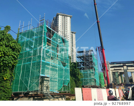 MELAKA, MALAYSIA -JULY 4, 2022: Installation of temporary scaffolding for the construction of tall concrete structures. Safety factors are prioritized to prevent accidents to workers and the public. MELAKA, MALAYSIA -JULY 4, 2022: Installation of temporary scaffolding for the construction of tall concrete structures. Safety factors are prioritized to prevent accidents to workers and the public. 92768997