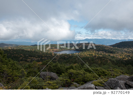 長野県南佐久郡の北八ヶ岳のメルヘン街道沿いの白駒池/白駒の森の高見石から観える紅葉と青空と雲と石 92770149