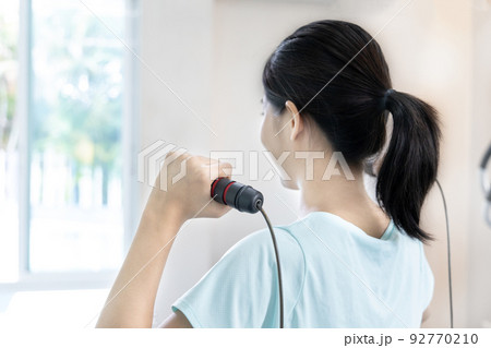 Beautiful and shapely Asian woman working out in the gym, Play exercise machine treadmill, Dumbbell, stretching, Hanging bar, Barbell, Cardio, Stretch, Woman warming up in the gym, Jump rope. 92770210