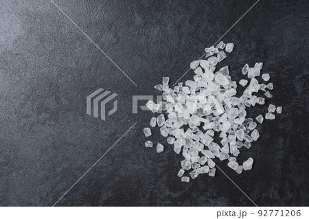 Sea salt in wooden bowl on black table. 92771206