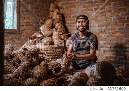 Water hyacinth craftsman smiling while making a basket Water hyacinth craftsman smiling while making a basket 92772600