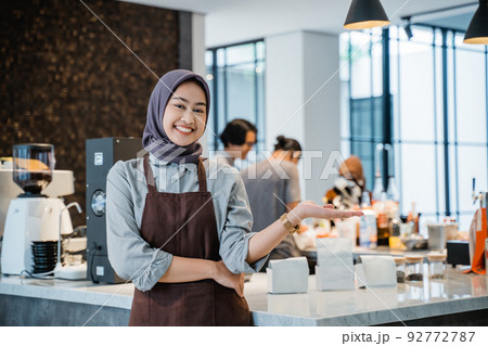 owner at her coffee shop welcoming customer to her newly open shop owner at her coffee shop welcoming customer to her newly open shop 92772787