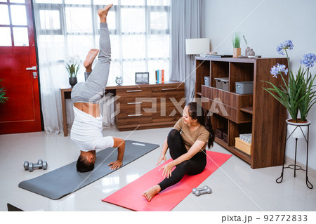 beautiful young couple doing exercise together at home 92772833