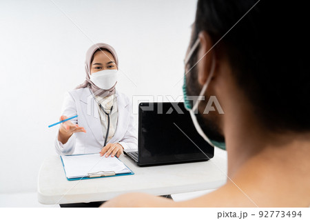 Doctor in a hijab asks a male prospective hajj pilgrim 92773494